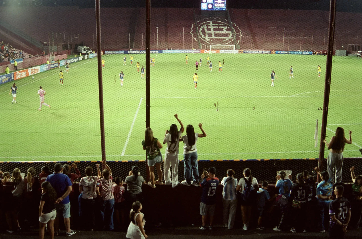 Cancha de Lanús con mujeres celebrando en la tribuna — fútbol femenino profesional en Argentina